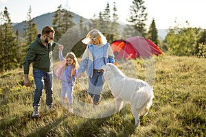 Happy couple with little girl have fun while travel in the mountains