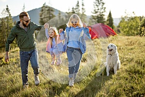 Happy couple with little girl have fun while travel in the mountains