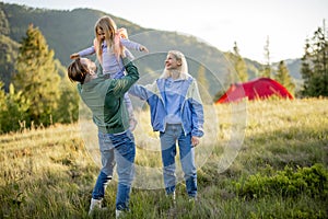 Happy couple with little girl have fun while travel in the mountains