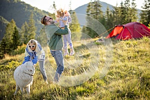 Happy couple with little girl have fun while travel in the mountains