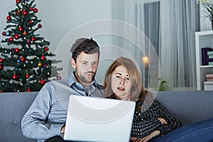 Happy couple look on laptop pc for christmas