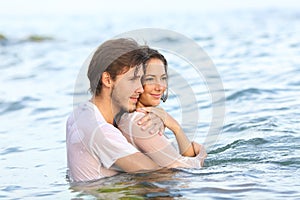 Happy couple looking away bathing on the beach