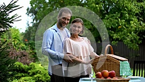 Happy couple looking at camera, preparing for picnic, social welfare, wellness