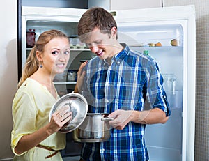 Happy couple looking food near fridge photo