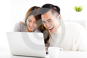 Happy Couple Looking at Laptop In living room