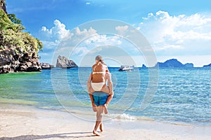 Happy couple in love boyfriend carrying his girlfriend in sea on