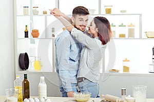 Happy Couple in love cooking dough and kissing in kitchen