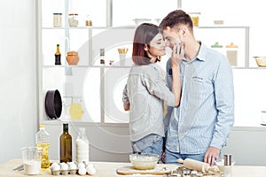 Happy Couple in love cooking dough and kissing in kitchen