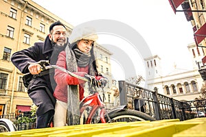 Happy couple in love enjoying winter time outdoor on vintage bicycle