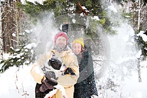 Happy couple in love having fun in the snow with his baby dog