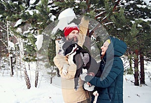 Happy couple in love having fun in the snow with his baby dog