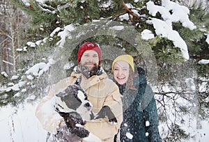 Happy couple in love having fun in the snow with his baby dog