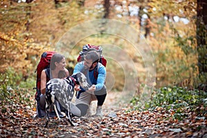 Happy couple in love at hiking trail with their pet