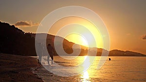 Happy couple in love holding hands running in tropical beach at sunset in slow motion. 1920x1080