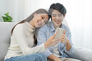 Happy couple love at home,beautiful two asian young spending good time together,bonding to each other and smiling romantic on sofa