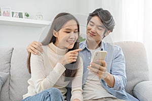 Happy couple love at home,beautiful two asian young spending good time together,bonding to each other and smiling romantic on sofa