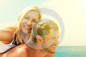 Happy couple in love hugging and laughing on the beach