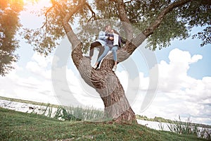 happy couple in love hugs standing on a big tree .