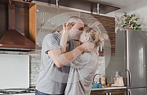 happy couple in love kissing in the kitchen smeared in flour