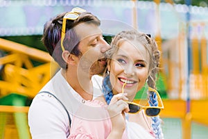 Happy couple in love kissing in an outdoor amusement park during leisure time Lifestyle concept of young people