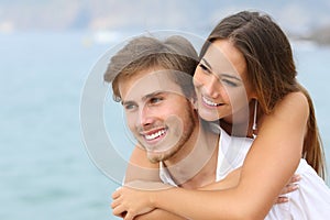 Happy couple in love with perfect smile on the beach