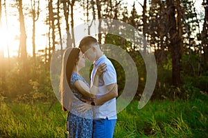 Happy couple in love in springtime at sunset. Woman and man holding hands and hugging.