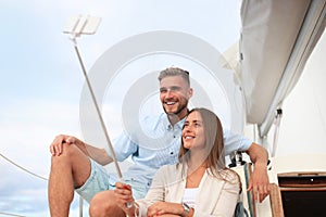 Happy couple in love taking selfie on sailing boat, relaxing on a yacht at the sea.