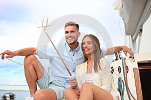 Happy couple in love taking selfie on sailing boat, relaxing on a yacht at the sea.