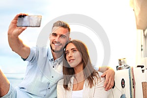 Happy couple in love taking selfie on sailing boat, relaxing on a yacht at the sea.