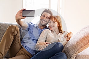 Happy couple in love taking a selfportrait with a cell phone.