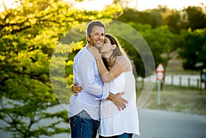 Happy couple in love together in park landscape on sunset with woman pregnant belly and man