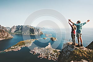 Happy Couple love and travel raised hands on cliff photo