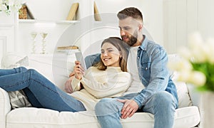 Happy couple in love using smartphone together