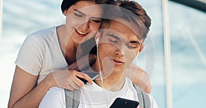 Happy couple in love using smartphone. Young married couple having fun in waiting for a flight at the airport. The woman