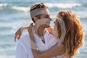 Happy couple in love walking on the beach