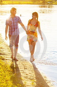 Happy couple in love walking on the beach. Summer vacations concept.