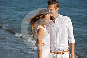 Happy couple in love walking on the beach