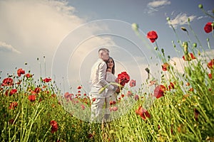 Happy couple in love walking in beautiful field of poppy flower on romantic day, wedding