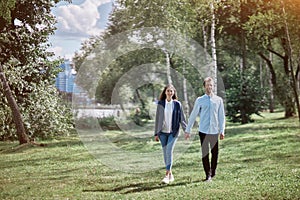 happy couple in love walking on the grass in the park .