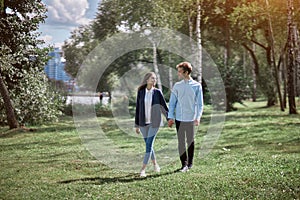 happy couple in love walking on the grass in the park .