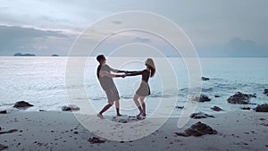 Happy couple lovers spins merrily against backdrop seascape. Couple is ready spin endlessly to sound waves, enjoying