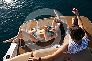 Happy couple lying on a boat at sea. Luxury vacation on a yacht in the islands.