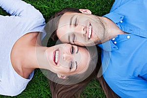 Happy couple lying on grass