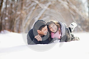 Happy couple lying on the snow and laughing