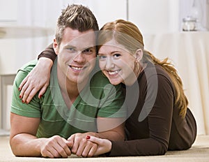 Happy Couple Lying Together On Their Floor