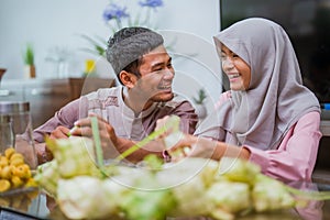happy couple making ketupat for idul fitri