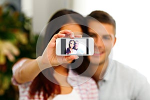 Happy couple making selfie photo with smarphone