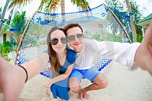 Happy couple making selfie relaxing in hammock