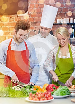 Happy couple and male chef cook cooking in kitchen