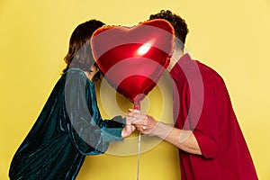 Happy couple, man and woman holding balloons shaped hearts. Valentine& x27;s day celebration. Concept of emotions, love